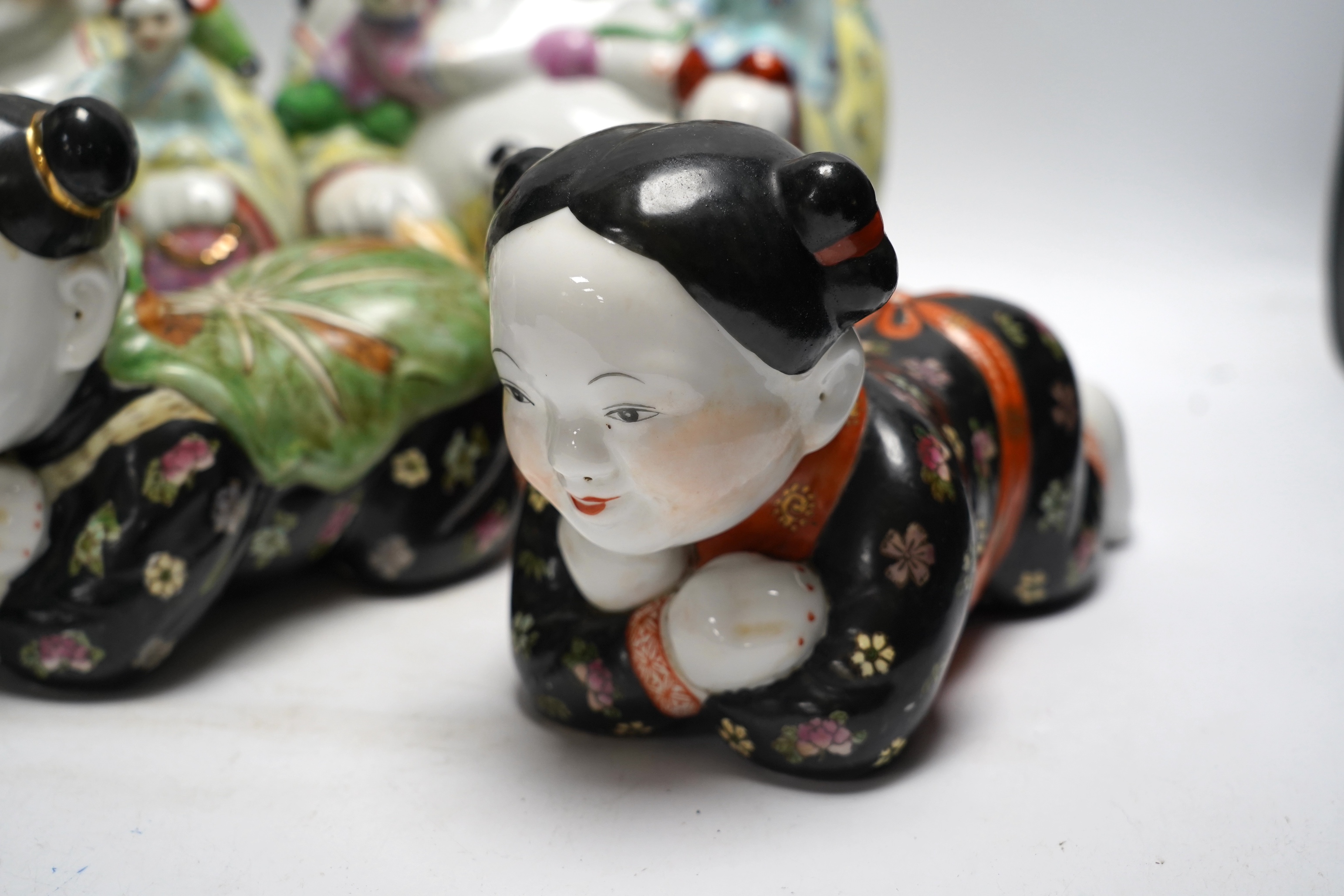Two figural Chinese pillows, two famille rose Budai groups and three yixing teapots, tallest 25cm